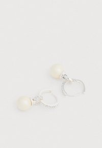 Σκουλαρίκια σε απόχρωση ασημί με μεγάλο λευκό μαργαριτάρι, συνδεδεμένα με κρίκο με μικρές διαφανείς στρας. Κομψός σχεδιασμός κρίκου με γυαλιστερό φινίρισμα.