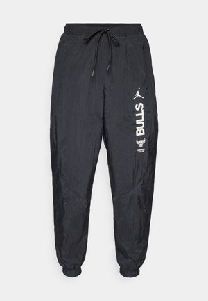 Fekete nylon joggingnadrág, rugalmas mandzsettával, húzózsinórral ellátott derékkal és fehér Chicago Bulls és Jumpman logókkal a jobb lábon.