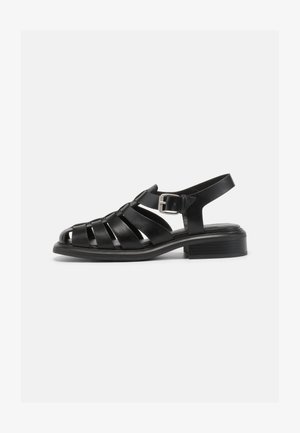 Black leather sandals with a strappy design, open toe, and ankle buckle. Features a low block heel and smooth, matte texture.