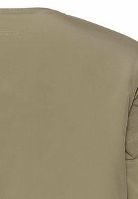 Khakifarbenes, leichtes Sweatshirt mit einer glatten Textur, runden Halsausschnitt und Nahtdetails an den Ärmeln. Subtile Markenkennung in der Nähe des Kragens.