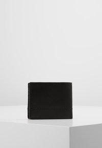 Portefeuille en cuir noir avec une texture lisse, design plié et couture visible. Forme compacte sans matériel ou motifs proéminents.
