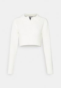 Vit croppad tröja med långa ärmar, ribbad fåll och krage. Tillverkad av mjukt stickat material med en texturerad yta.