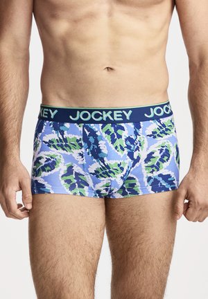 Male torso wearing blue, green, and white leaf-patterned boxer briefs with a navy waistband labeled "JOCKEY" in light blue.