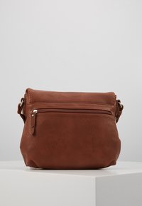 Borsa a tracolla in pelle marrone con tasca anteriore con zip, texture morbida, forma arrotondata e tracolla regolabile.