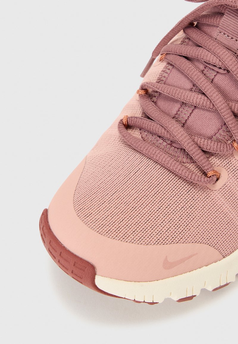 Nike Sneaker mit einem Obermaterial aus pinkem und mauvefarbenem Mesh, verstärktem Zehenbereich, flachen Schnürsenkeln, Gummisohle und dezenten Logodetails in der Nähe der Ferse.