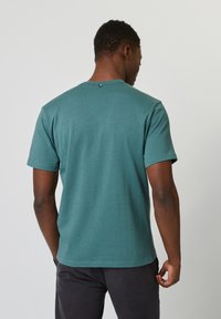 Teal T-shirt met korte mouwen, gemaakt van een zachte katoenmix, met een ronde hals en een klein accentdetail op de rug.