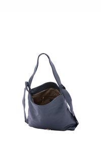 Borsa a spalla in pelle blu navy con un design morbido, texture soffice e manici lunghi. L'interno presenta una tasca con zip e una fodera marrone.