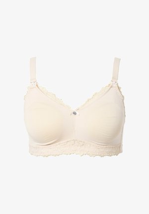 Zachte beige draadloze beha met verstelbare bandjes, kanten rand langs de bovenste randen en onderband, en een kleine decoratieve strik met een knoop in het midden.