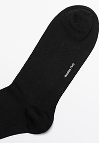 Calzino nero alla caviglia con texture liscia e punta arrotondata. Il nome del marchio "Massimo Dutti" è stampato in bianco sul lato.