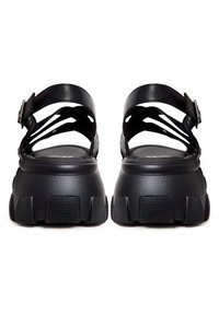 Zwarte sandalen met een chunky hak, met een bovenwerk van soepel leer, meerdere banden en een structuur rubberen zool voor grip.