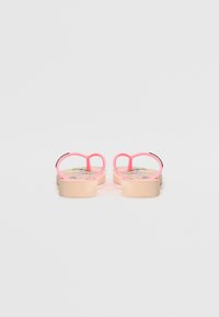Rosa flip-flops med hjärtformade remmar, en slät sula och en färgglad mönstrad innersula med blommönster.