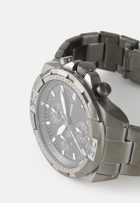 Fossil Chronograph-Uhr mit Edelstahlarmband, schwarzem Ziffernblatt, silbernen Akzenten, strukturiertem Gehäuse und Datumsanzeige um 3 Uhr.