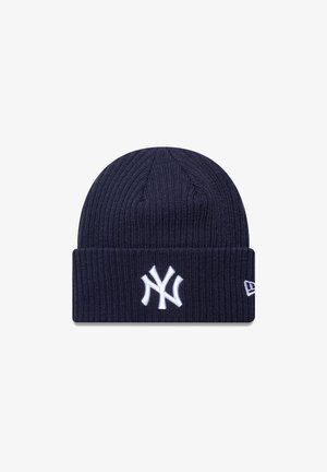 Námornícky modrá pletená čiapka s ryhovanou textúrou, s bielym vyšitým logom New York Yankees a ohnutým lemom na spodnej časti.