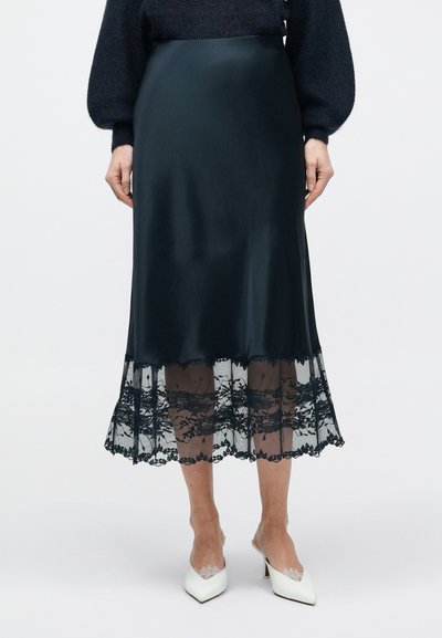 Satijnen midirok in donker teal met een doorschijnende kanten zoom met ingewikkelde bloemmotieven. Glad van textuur met een aangesloten tailleband.