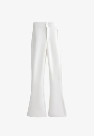 Hvide flagrende bukser lavet af glat stof. Har en lynlås og to knaplukninger samt sidelommer med lynlås. Sømdetaljer gennem hele bukserne.