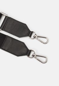 Black textured leather strap with silver metallic hardware and snap hooks, featuring a rectangular padded section and a woven fabric element.