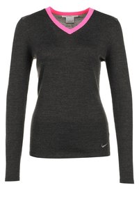 Haut à manches longues et col en V gris foncé avec un liseré de col rose vif et un petit logo Nike argenté sur le bas côté droit. Texture de tissu douce.