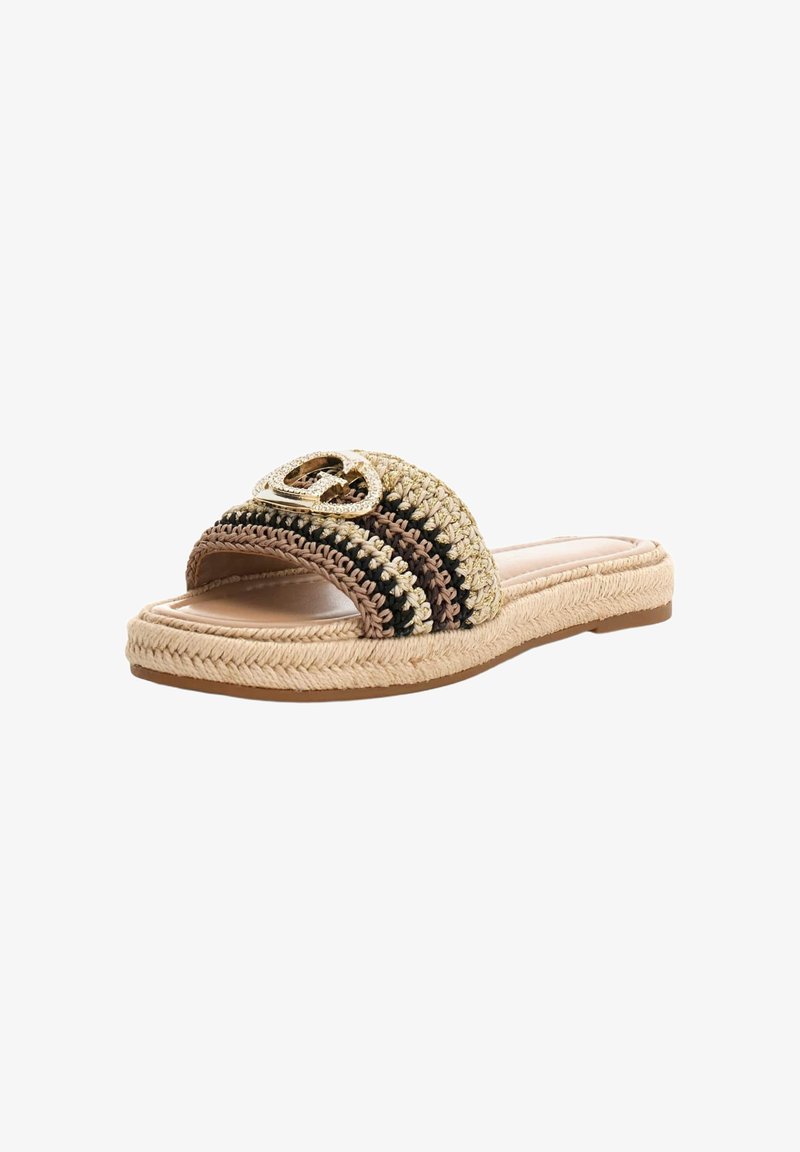 Sandale slide tissée avec des rayures beige, marron et noires et un emblème décoratif doré sur la sangle supérieure, semelle plate en jute tressée.