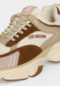 Chunky sneaker σε μπεζ, καφέ και ροζ με υφές από δίχτυ και σουέντ, μπροστινή δέση με κορδόνια και "LOVE MOSCHINO" τυπωμένο στο πλάι και στη γλώσσα.
