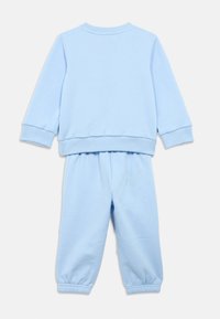 Σετ γαλάζιας μπλούζας φούτερ και φόρμας από μαλακό βαμβακερό ύφασμα, με ριμπ μανσέτες και μέση, σε άνετη εφαρμογή και με λεία υφή.