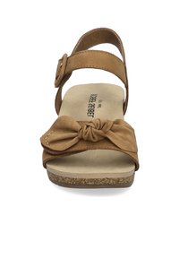 Bruine leren sandaal met een geknoopte voorband, verstelbare enkelband en een kurken zool. Platte ontwerp met een brede tenenruimte.