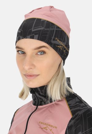 Pink and black beanie featuring a geometric pattern, made of stretchy fabric. Includes "SWEDEMOUNT" logo in gold on the front.