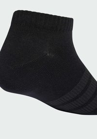 Calcetín negro hasta el tobillo hecho de un tejido texturizado, con un puño acanalado y rayas horizontales a lo largo del costado como detalle de diseño.