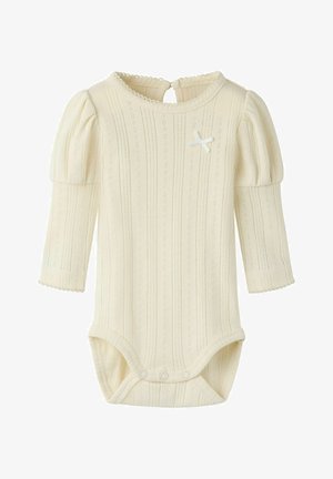 Cream-colored long-sleeve baby onesie with puffed shoulders, eyelet knit pattern, back button closure, and small decorative bow on chest.