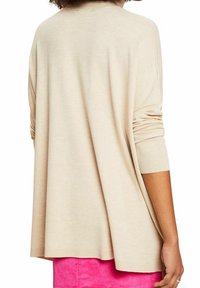 Beżowy luźny sweter z okrągłym dekoltem, długimi rękawami i ściągaczami, z delikatnie opadającym tyłem.