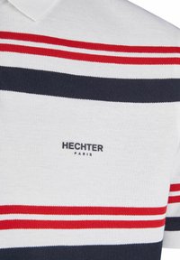 Polo shirt in wit met rode en marineblauwe horizontale strepen. Heeft een gestructureerde stof en een zwart "HECHTER PARIS" logo op de voorkant.