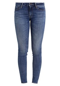 Pantalones vaqueros ajustados de mezclilla azul con cierre frontal de botón y cremallera, bolsillos delanteros y traseros, y un ligero desvanecimiento en los muslos y las rodillas.