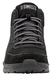 Zwarte K-Swiss sneaker met grijze veters, bovenwerk van suede en stof, met een merklabel op de tong en een getextureerde rubberen zool die naar voren gericht is.