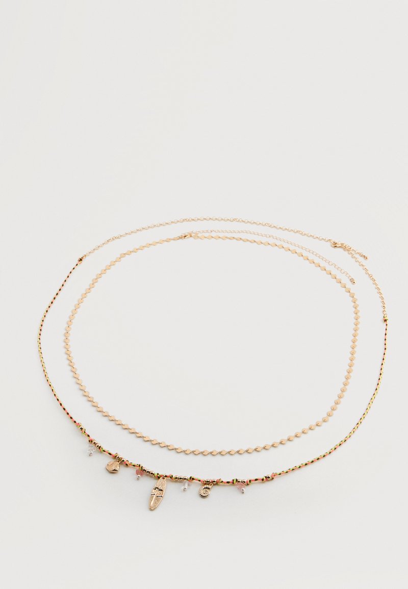 Dwa delikatne naszyjniki w złotym odcieniu na białym tle; jeden z cienkim łańcuszkiem z geometrycznymi ogniwami, drugi pleciony z małymi złotymi zawieszkami.