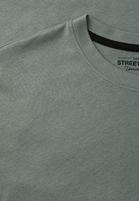 Light green cotton t-shirt featuring a crew neck, short sleeves, and flat seams. Label reads "Street" with a subtle black accent on the neck.