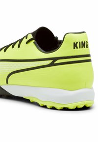 Scarpa da calcio gialla brillante con accenti neri, realizzata in materiale sintetico testurizzato, design perforato e un distintivo marchio "KING" sul tallone.