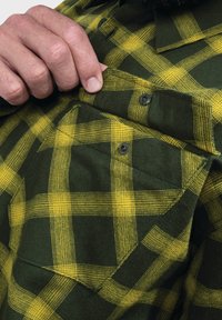 Grün- und gelbkariertes Hemd mit einer Brusttasche, die zwei schwarze Knöpfe hat, strukturiertem Stoff und einem klassischen Kragendesign.