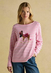 Dlhý rukáv koše�ľa s ružovými a bielymi pruhmi, s hnedým vyšitým dizajnom lamy, ktorá drží vianočnú ponožku. Bavlnený materiál.