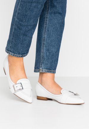 Hvide flade sko med spids tå og en dekorativ sølvspænde. Fremstillet af glat læder med kontrasterende syninger.