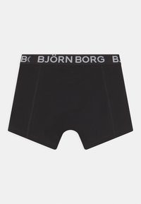 Svarte boxershorts laget av mykt stoff med en bred, elastisk midje med "BJÖRN BORG" trykt i hvitt. Synlige sømdetaljer.