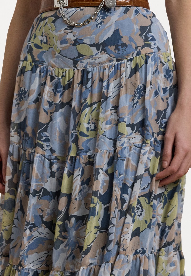 Kwiatowa spódnica maxi, z warstwowymi tierami z miękkiego materiału. Przeważająca niebieska z beżowymi i zielonymi kwiatami, wykończona delikatną teksturą.