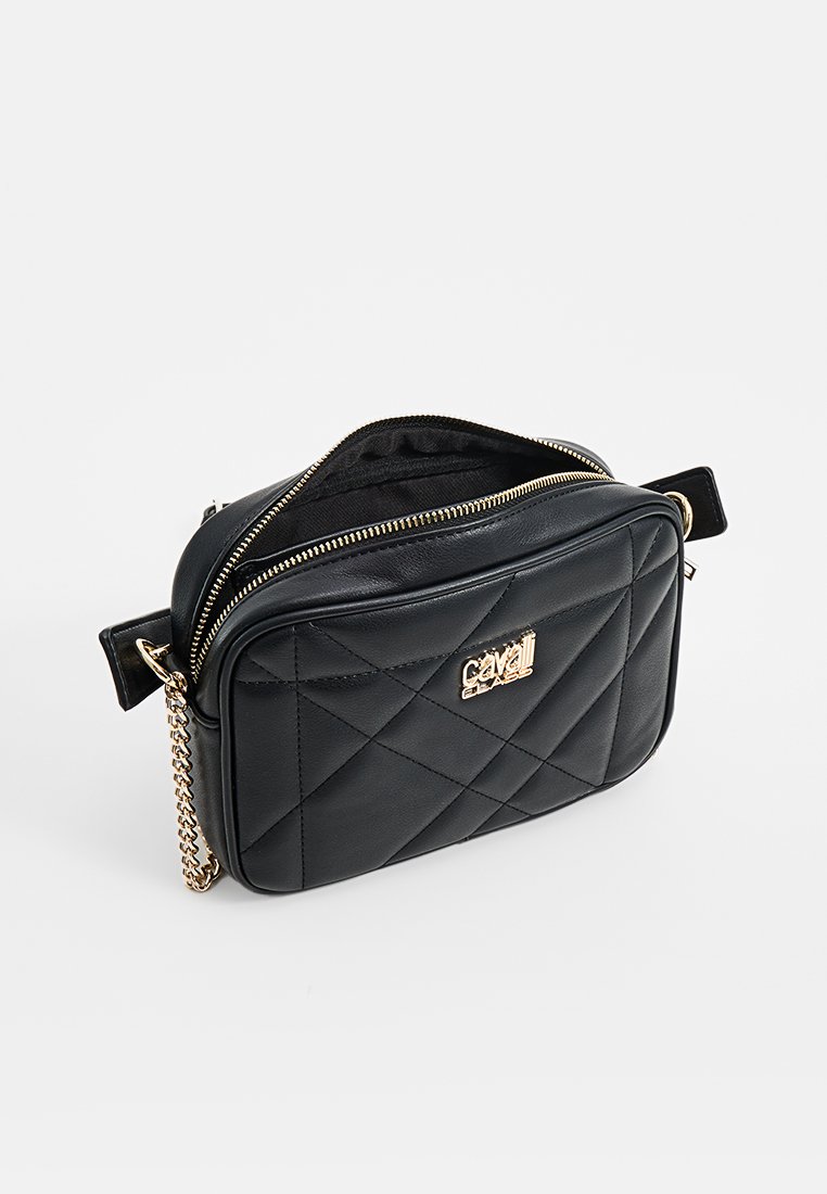 Bolso bandolera de cuero negro acolchado con herrajes dorados, cierre de cremallera y correa de cadena. Presenta una forma rectangular con detalle del logo.