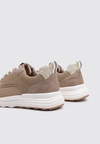 Sneakers beige in materiale mesh e suede, punta rotonda, suola bianca e accenti grigi sul tallone e sulla lingua. Presentano lacci piatti.