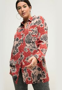 Camicia a maniche lunghe con sfondo rosso e motivi floreali e leopardati neri. Realizzata in tessuto morbido con design a bottoni.