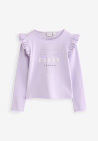 Lila majica dugih rukava s detaljima od volana na ramenima i ispisanom oznakom "BAKER LONDON" s velikim "T" u središtu. Mekani materijal.