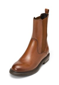 Bottine en cuir marron avec des panneaux latéraux élastiques, design élancé, bout rond et semelle en caoutchouc texturée. Elle est dotée d'une sangle arrière pour un enfilage facile.
