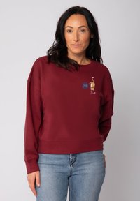 Bordeaux sweatshirt met ronde hals en een losse pasvorm. Heeft een geborduurd cartoonontwerp en een kleine spraakwolk graphic op de voorkant.