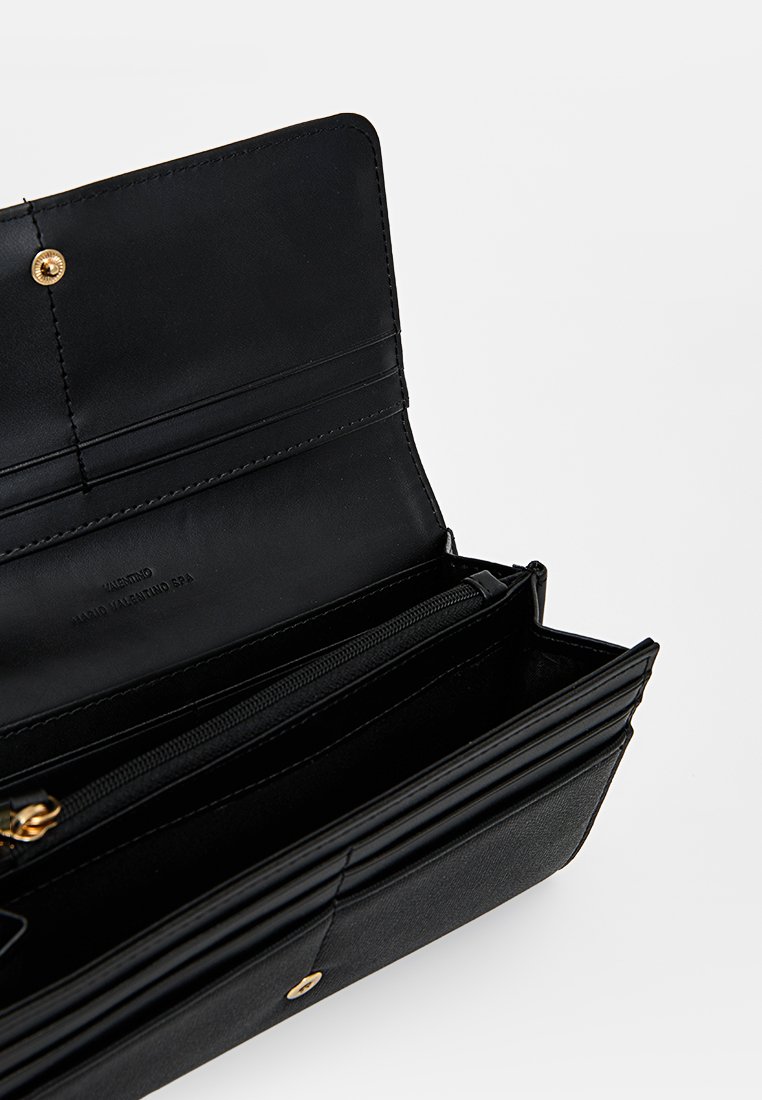 Portefeuille en cuir noir avec une texture lisse, comportant un compartiment zippé, plusieurs emplacements pour cartes et une fermeture à pression. Accents en matériel doré.