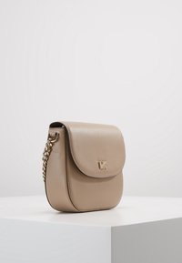 Kahvinahkainen olkalaukku kannella, ketjuhihnalla ja kultaisella logolla edessä, joka esittelee sileän pinnan.