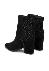 Botines de ante negros con tacones gruesos, cremalleras laterales y patrones decorativos de tachuelas circulares en los laterales exteriores.