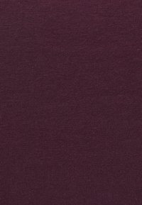 Tessuto a maglia di un solido viola scuro con una fine texture a costine, tessuto uniformemente e consistente nel colore e nel motivo.